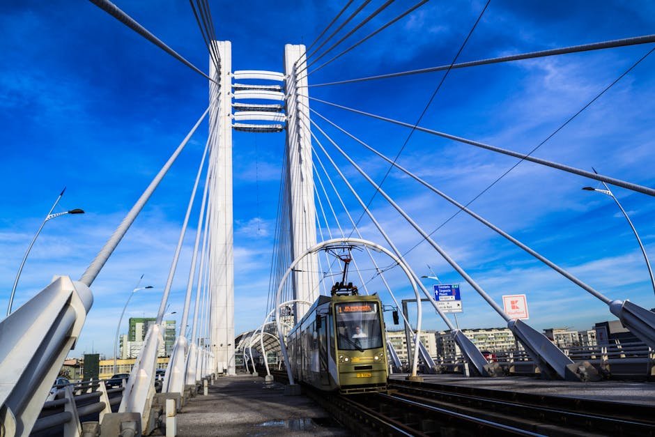 A modern urban bridge featuring an electric train in Bucharest during a clear day.